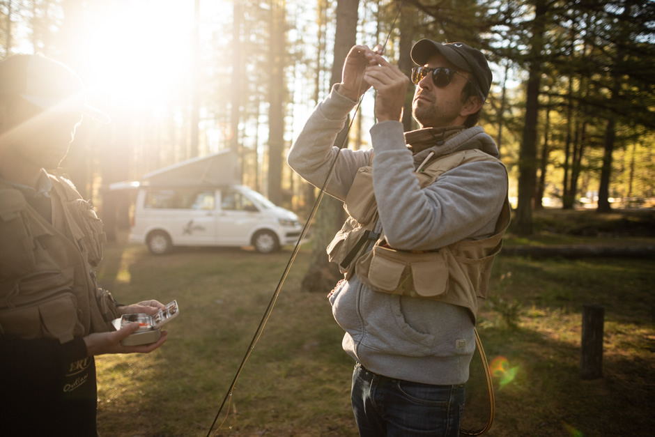 A man is adjusting his fishing rod