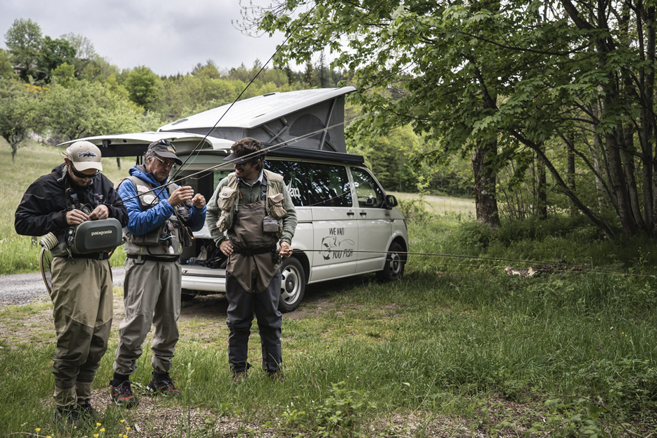 Trois hommes se préparent pour pêcher à la mouche