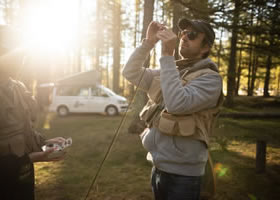 A man is adjusting his fishing rod