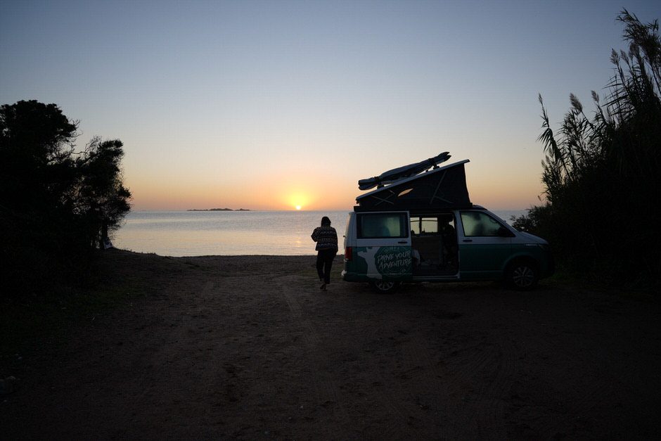 Van aménagé stationné sur une plage en Corse