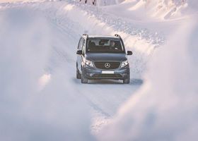 A Mercedes hired minibus drives down the road