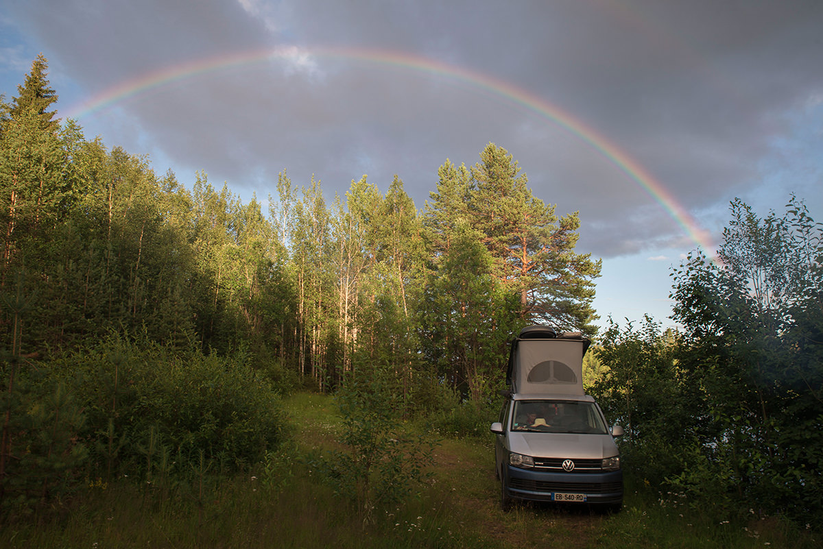 Van aménagé sous un arc-en-ciel 