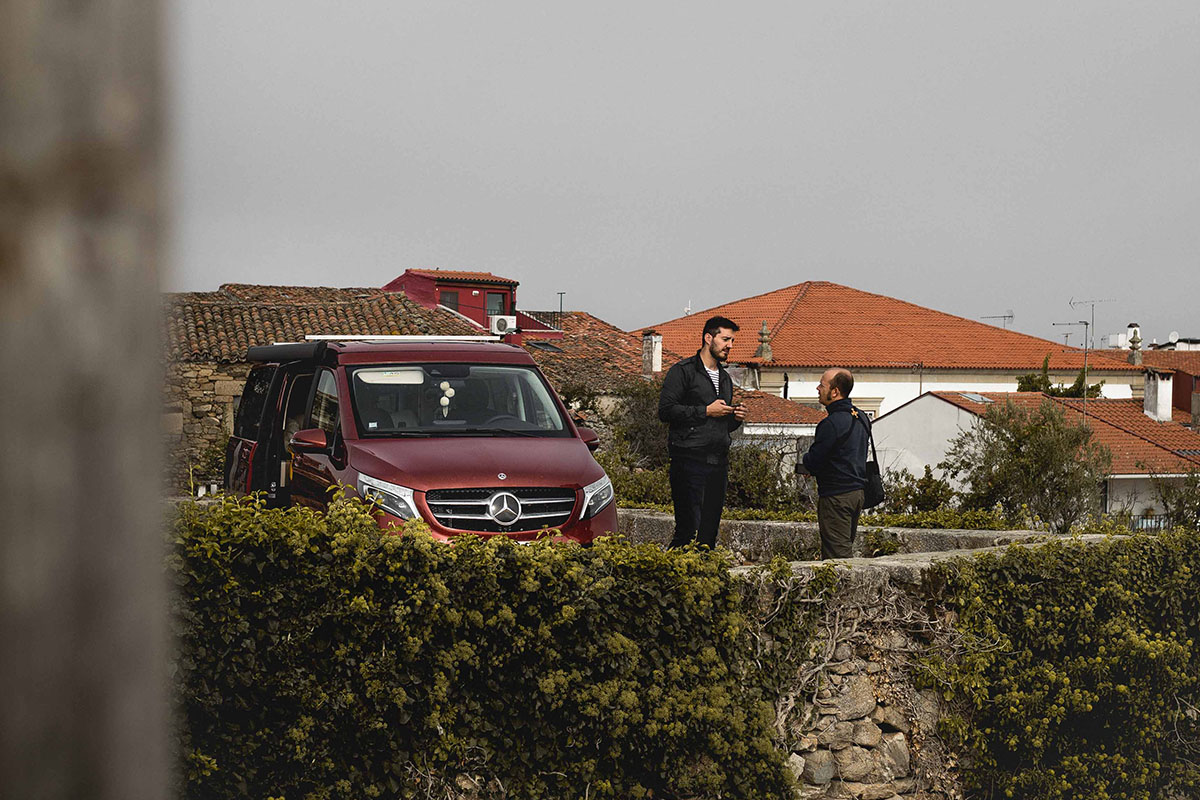 Deux hommes discutant devant un campervan au Portugal