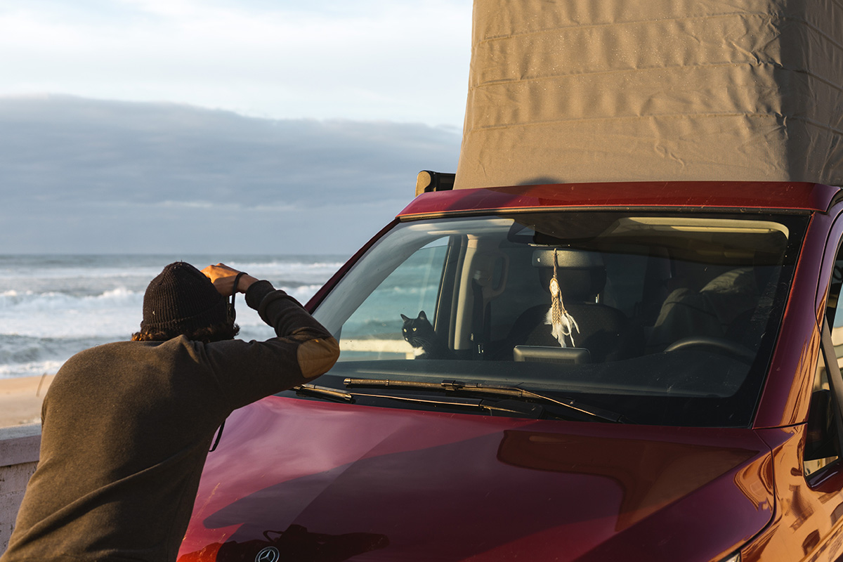 Homme prenant en photo un van aménagé