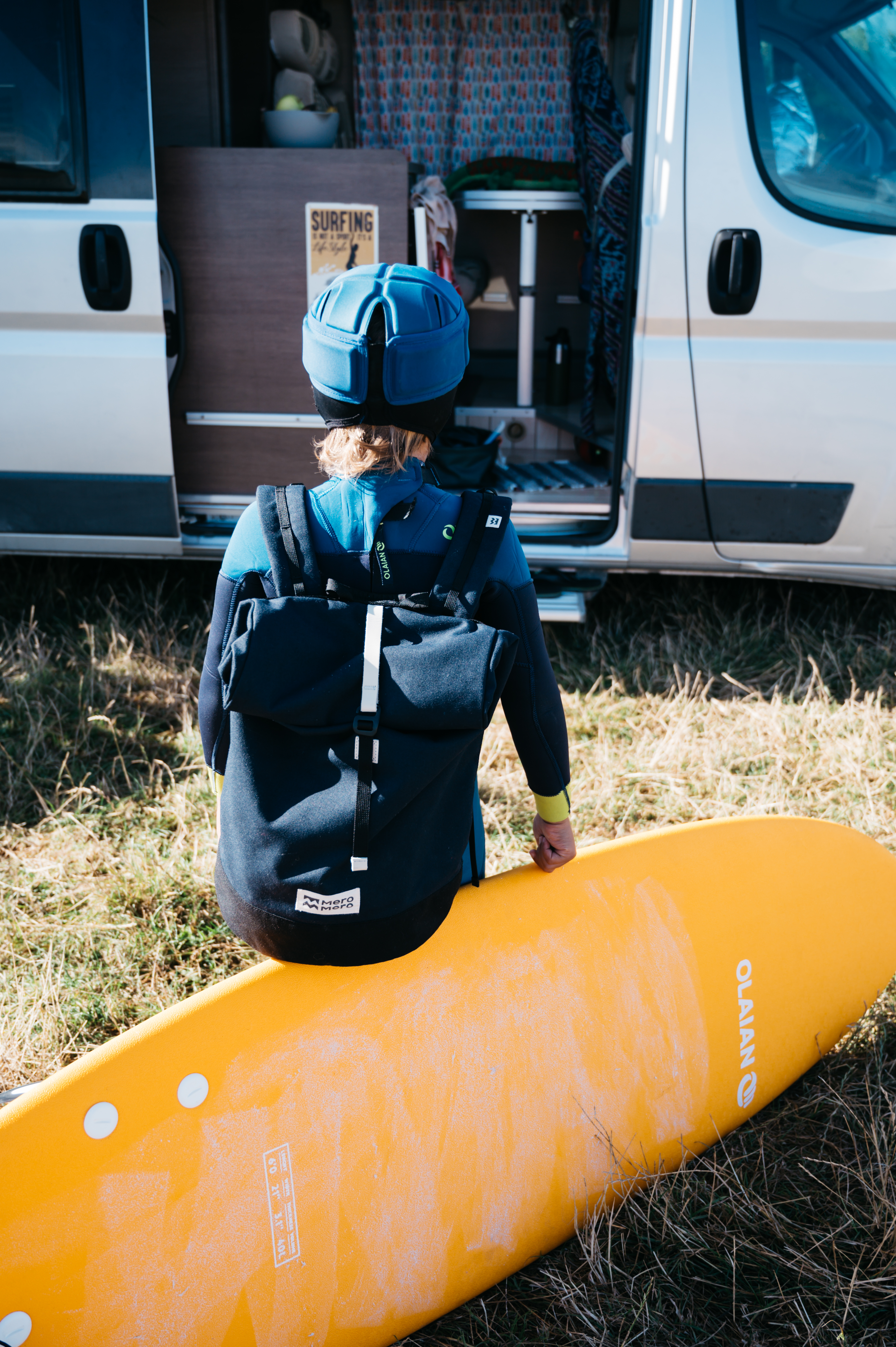 Enfant surfeur rentrant dans un van aménagé
